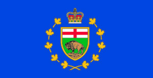 Lieutenant Governor's Standard flag - blue flag with the shield of the arms of manitoba at its centre, circled with 10 gold maple leaves with gold crown on top.